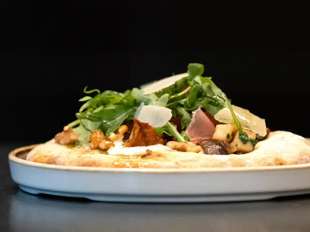 Potato pancakes with sour cream, arugula and bacon