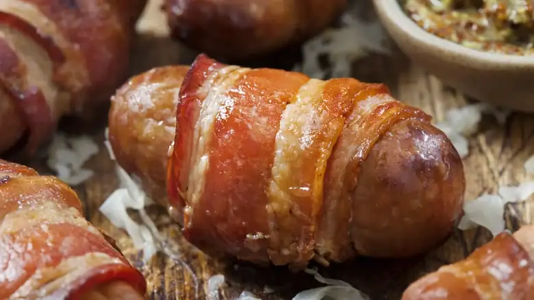 Wrapping the bratwurst in bacon is a simple addition that enhances the flavor.