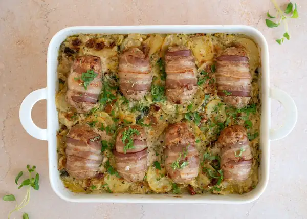 Bacon rolls in a potato dish with vegetables