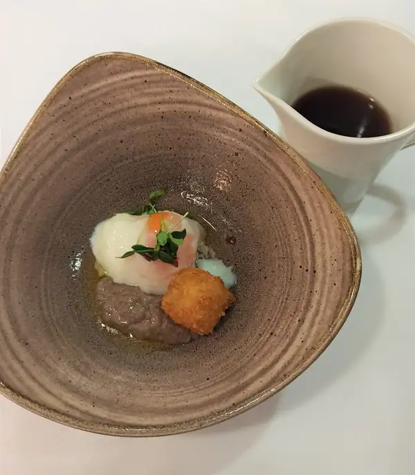 Huevo cocido a fuego lento, consomé de cebolla texturizado y tempura de queso Comté