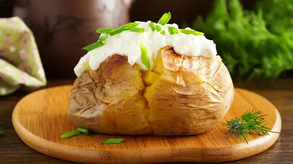 Give Baked Potatoes A Hearty German-Style Upgrade With One Tangy Addition