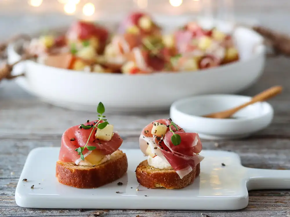 Crostini con jamón curado, manzana y crema de rábano picante