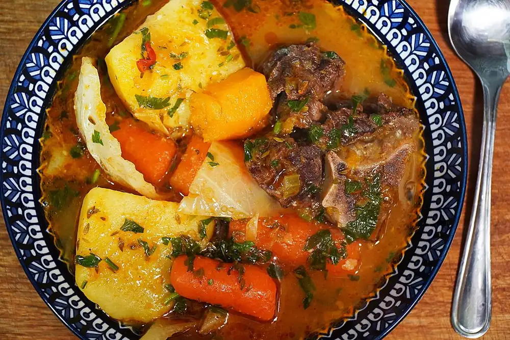 Reconfortante sopa caribeña de huesos de res con verduras de raíz