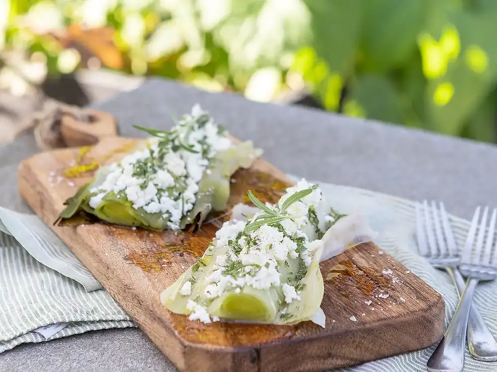Puerros enteros asados con miel, queso feta y romero
