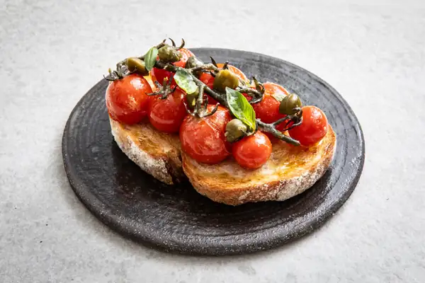 Receta de tomates confitados Piccolo sobre tostadas con anchoas y alcaparras