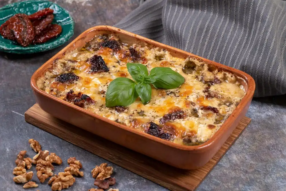Chicken breast with walnuts and cheese in a casserole dish