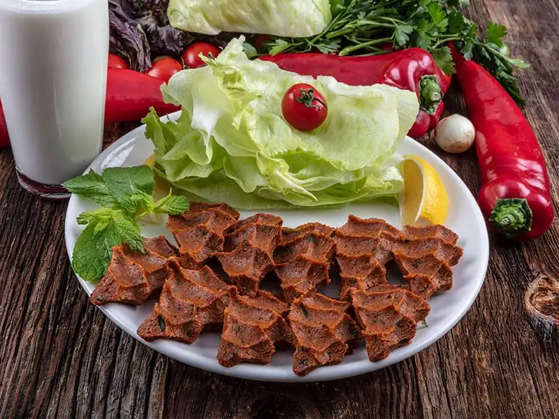 What gives raw meatballs (çiğ köfte) their dark color?