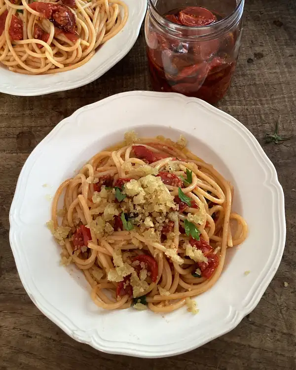Receta de Rachel Roddy para espaguetis con tomates semisecos, ajo, hierbas y pan rallado
