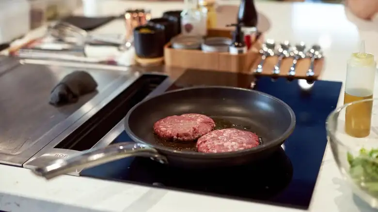 You don't need much oil to cook hamburgers in a pan.